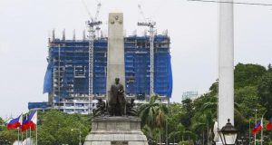 The Torre de Manila under construction seen behind the Rizal Monument