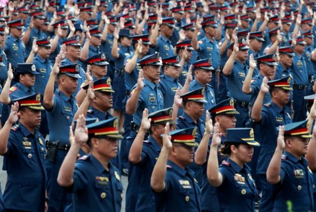 Police officers take their oath at the Philippine National Police headquarters in Quezon
