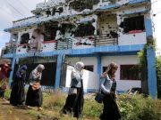 Marawi_walking_past_ruined_house-648_REU