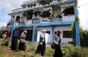 Marawi_walking_past_ruined_house-648_REU