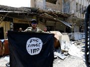 A member of the Emergency Response Division holds an Islamic State militants flag in the Old City of Mosul