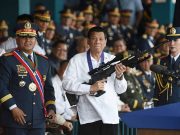 Philippine President Rodrigo Duterte holds a Galil sniper rifle next to outgoing Philippine National Police Chief Ronald Bato Dela Rosa during the National Police chief handover ceremony in Camp Crame