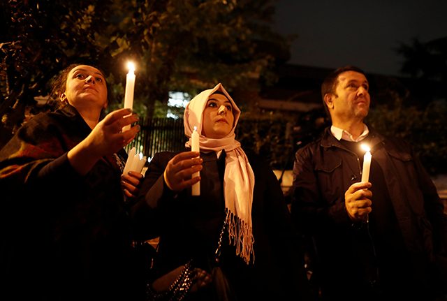 Demonstrators hold candles for Saudi journalist