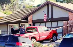Police and FBI officer wait outside the home of the suspect
