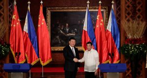 China's President Xi Jinping and Philippine President Rodrigo Duterte shake hands after a joint news statement at the Malacanang presidential palace in Manila