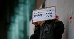 A man holds a sign calling for China to release Wang Bingzhang and former Canadian diplomat Kovrig, who was arrested in China on Tuesday, outside the B.C. Supreme Court bail hearing of Huawei CFO Meng Wanzhou