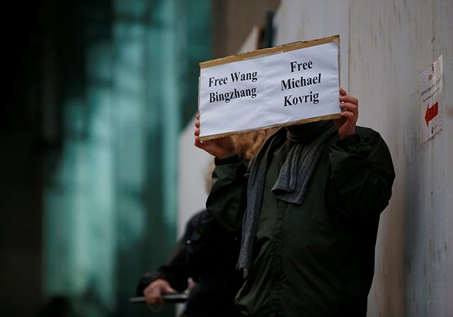 A man holds a sign calling for China to release Wang Bingzhang and former Canadian diplomat Kovrig, who was arrested in China on Tuesday, outside the B.C. Supreme Court bail hearing of Huawei CFO Meng Wanzhou