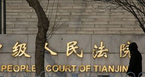 A man walks past the courthouse where prominent rights lawyer Wang Quanzhang is being tried in Tianjin
