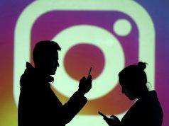 Silhouettes of mobile users are seen next to a screen projection of Instagram logo in this picture illustration