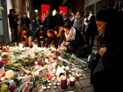 People cry as they light candles in tribute to the victims of the deadly shooting in Strasbourg