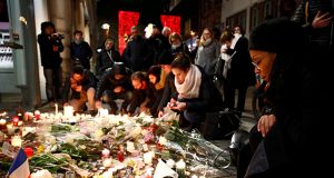 People cry as they light candles in tribute to the victims of the deadly shooting in Strasbourg