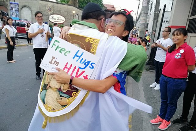 Priest hugs man with HIV