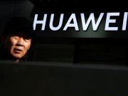 A man walks past a Huawei phone retail shop in Beijing