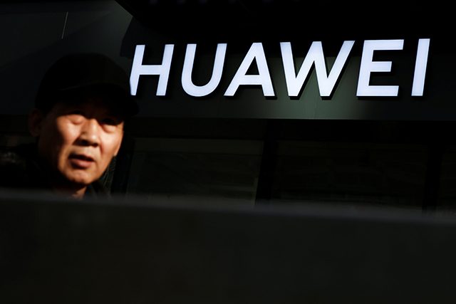 A man walks past a Huawei phone retail shop in Beijing