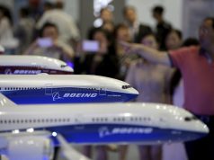 FILE PHOTO: Visitors look at models of Boeing aircrafts at the Aviation Expo China, in Beijing, China