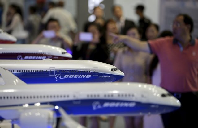 FILE PHOTO: Visitors look at models of Boeing aircrafts at the Aviation Expo China, in Beijing, China