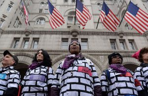 Women wear wall protest outfits as they stand in front of the Trump International Hotel while participating in the Third Annual Women's March in Washington
