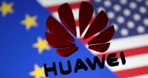 A 3D printed Huawei logo is placed on glass above displayed EU and US flags in this illustration