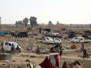 Fighters of Syrian Democratic Forces (SDF) walk together in the village of Baghouz, Deir Al Zor province