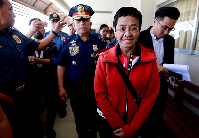 Rappler CEO and Executive Editor Ressa is escorted by police after posting bail in Pasig Regional Trial Court in Pasig City