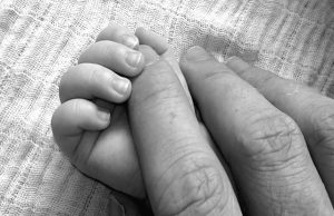 Infant's hand with adult