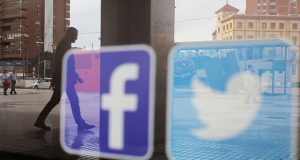 Facebook and Twitter logos are seen on a shop window in Malaga