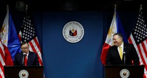 Philippine Foreign Secretary Teodoro Locsin Jr. speaks to the media as U.S. Secretary of State Mike Pompeo smiles at him at the Department of Foreign Affairs in Pasay City