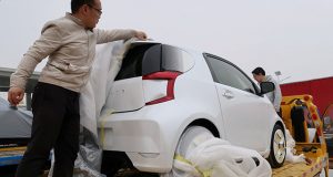 Singulato workers unwrap a concept car in preparation for the auto show in Shanghai
