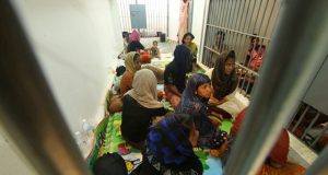 Rohingya people are seen detained in a police station after a fishing boat carrying more than sixty Rohingya refugees was found beached at Rawi island