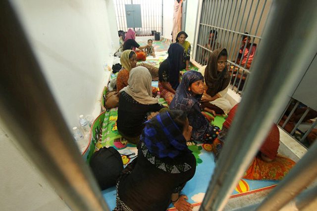 Rohingya people are seen detained in a police station after a fishing boat carrying more than sixty Rohingya refugees was found beached at Rawi island