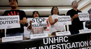 Members of the human rights groups hold banners calling to investigate Philippine President Rodrigo Dutere