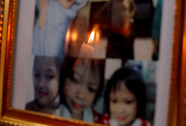 Candle is reflected off framed photos of 3-year-old Ulpina at her wake in Rodriguez, Rizal province
