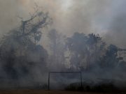 A fire burns a tract of Amazon jungle as it is cleared by loggers and farmers behind a soccer field near Porto Velho
