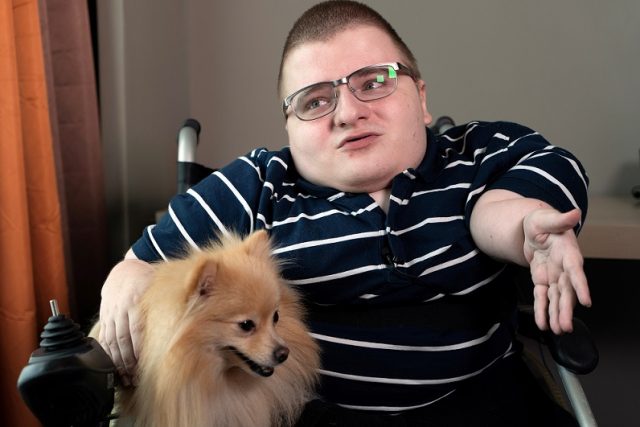 Online message board 8chan creator Fredrick Brennan gestures while sitting with a pet dog during an interview in Manila