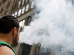 A man uses a vape as he walks on Broadway in New York City