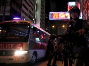 Riot police patrol streets near Mong Kok police station during an anti-extradition bill protest, in Hong Kong