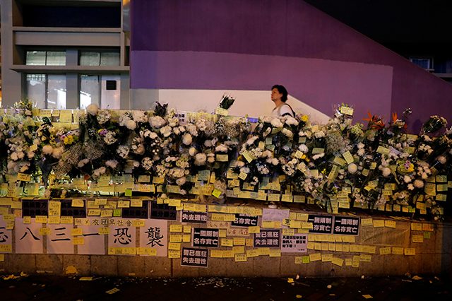 People pay their respects to the protesters who were injured during clashes with the police by placing flowers outside Prince Edward station, in Hong Kong