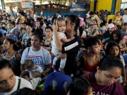Mothers hold their children while waiting in line to receive free polio vaccine during a government-led mass vaccination program in Quezon City