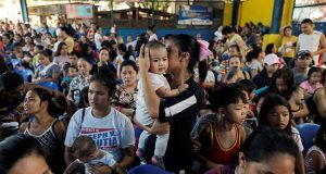 Mothers hold their children while waiting in line to receive free polio vaccine during a government-led mass vaccination program in Quezon City