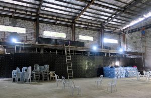Chairs are stacked inside an unfinished structure, formerly the media centre for soccer at the Southeast Asian Games, in Rizal Memorial Stadium