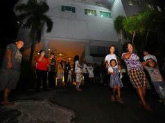 Visitors gather outside a hotel building following the earthquake that hit in Manado