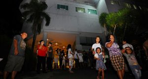 Visitors gather outside a hotel building following the earthquake that hit in Manado
