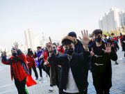 Hongkongers gesture as they chant slogans before a soccer match between Hong Kong and China outside Busan Asiad Stadium in Busan