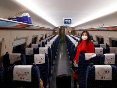 A woman wears a face masks as she travels on a high-speed train near Jiujiang