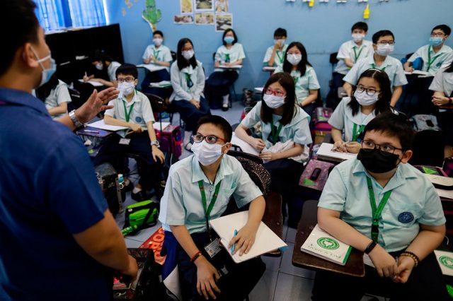 Students wear masks amid a health scare over a new virus that has infected thousands since emerging in China, in a Chinese school in Quezon City