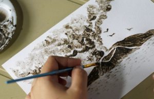 Filipina artist Janina Sanico paints an image of Taal volcano