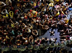Filipino devotees rest in front of a police barricade as they wait for the statue of the Black Nazarene during its feast day at Quiapo in Manila