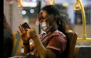 Person with mask using smartphone