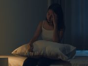 Woman sitting on bed
