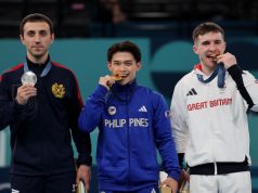 Carlos Yulo biting medal